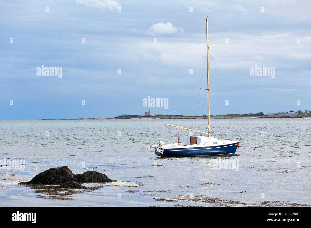 Barca a vela all'ancora a Saint Vaast la Hougue, sullo sfondo l'isola di Ile Tatihou. Penisola del Cotentin, Normandia, Francia Foto Stock