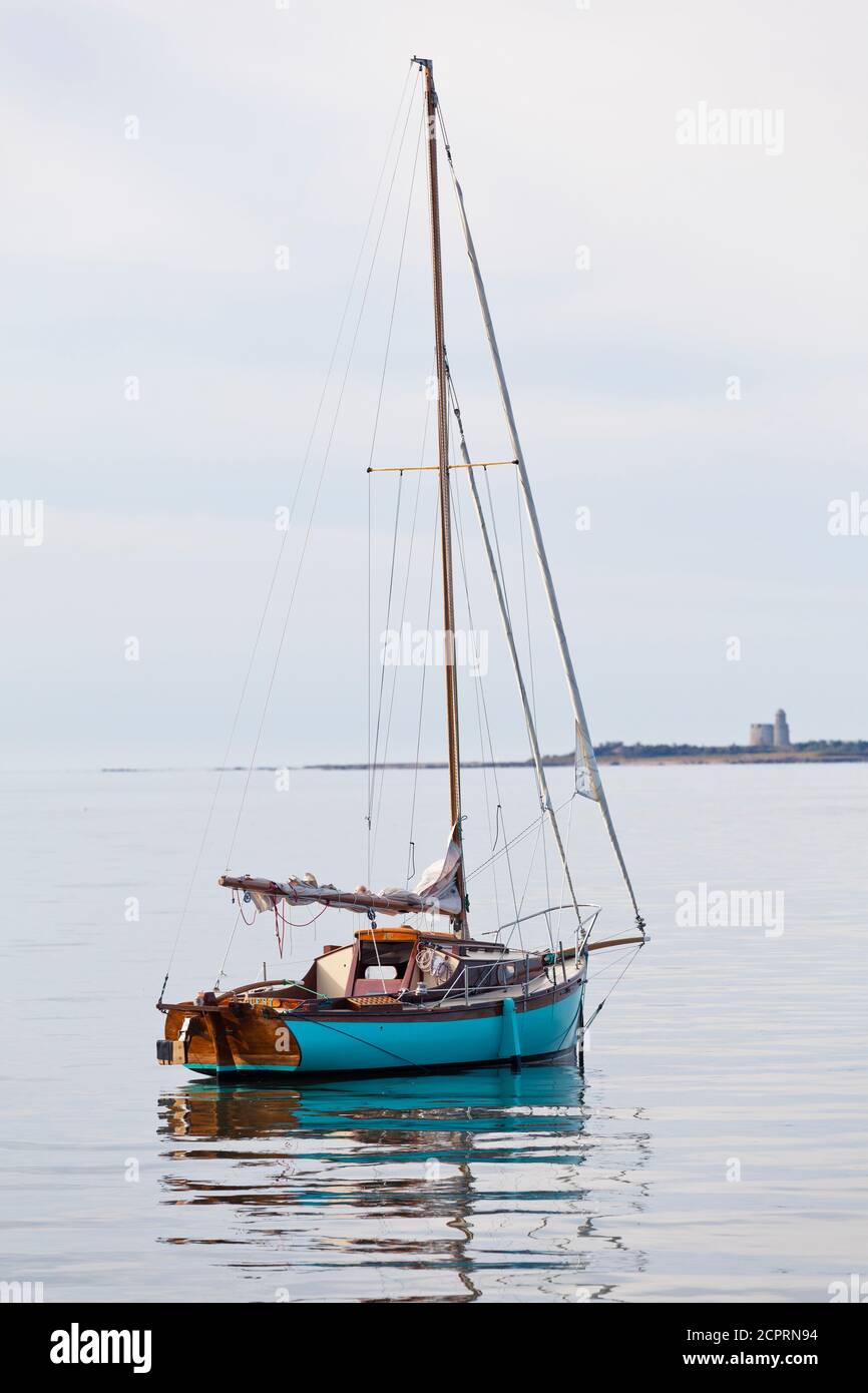 Barca a vela all'ancora a Saint Vaast la Hougue, sullo sfondo l'isola di Ile Tatihou. Penisola del Cotentin, Normandia, Francia Foto Stock