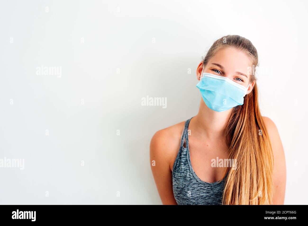 ritratto di una ragazza in abbigliamento sportivo che indossa una maschera protettiva contro virus covid con atteggiamento positivo Foto Stock
