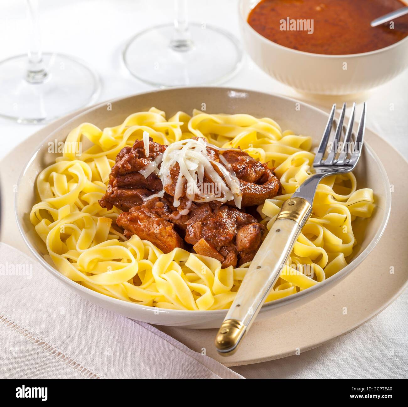 Delizioso piatto di pollo servito con tagliatelle di pasta Foto Stock