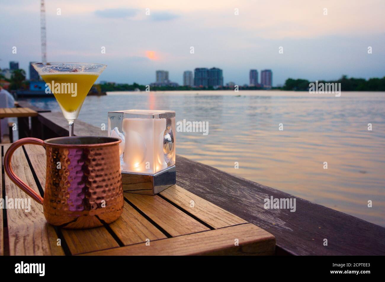 Serata rilassante sul fiume con un cocktail e una tazza di rame Foto Stock