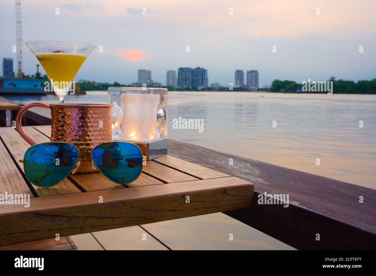 Serata rilassante sul fiume con un cocktail e una tazza di rame Foto Stock