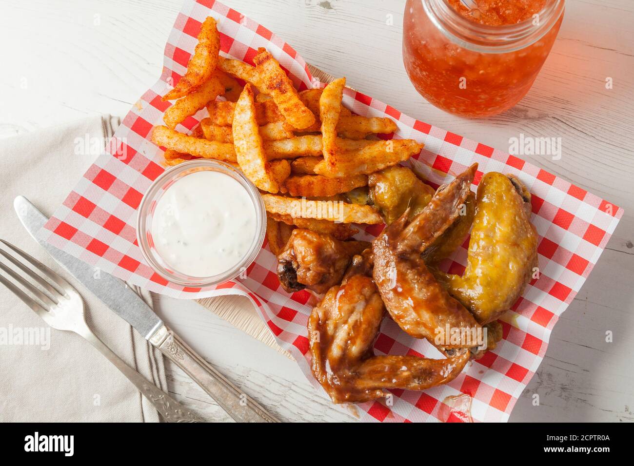 Ali di pollo speziate e patatine fritte in un ristorante fast food. Foto Stock
