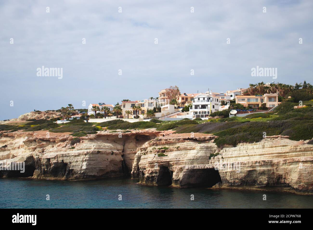 Cipro, Mar Mediterraneo, Grotte del Mare, Costa rocciosa con una città sopra Foto Stock