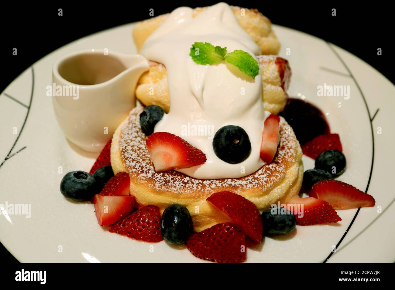 Closeup un piatto di Pancake Souffle con fresche Berries mix E Mascarpone Crema Foto Stock
