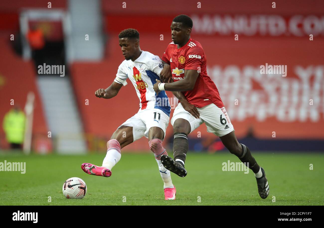 Wilfried Zaha di Crystal Palace (a sinistra) e Paul Poggiba di Manchester United per la palla durante la partita della Premier League a Old Trafford, Manchester. Foto Stock