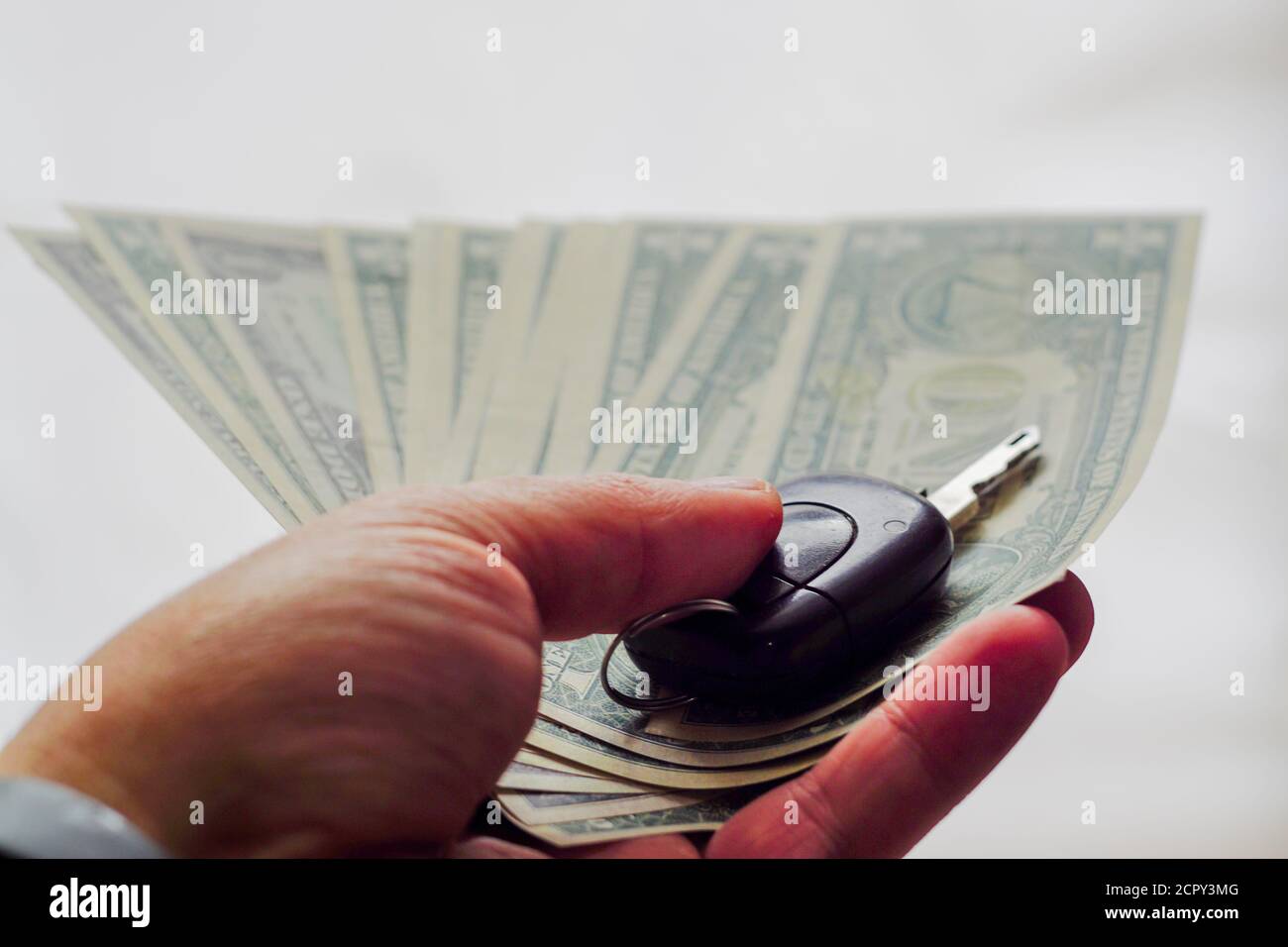 Chiave auto in vista ravvicinata mano uomo su isolato sfondo Foto Stock