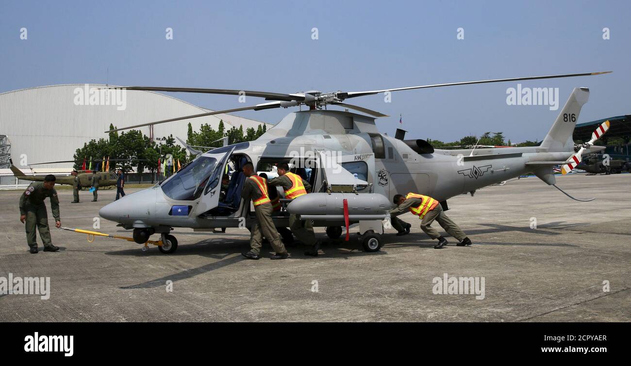 I membri dell'aeronautica filippina spingono uno dei due nuovi elicotteri AW-109E di nuovo ad un hangar dopo una cerimonia di turnover alla sede dell'aeronautica filippina (PAF) nella base aerea di Villamor nella città di Pasay, metropolitana Manila 17 agosto 2015. Le Filippine hanno ricevuto 10 nuovissimi elicotteri Bell-412EP e AW-109E dal Canada e dall'Italia per potenziare le capacità delle forze aeree di fornire un supporto aereo e una ricognizione aerea ravvicinato nelle operazioni di contrinsurrezione e nel trasporto per l'assistenza umanitaria e la risposta alle catastrofi, ha detto un funzionario dell'aeronautica filippina. REUTERS/Romeo Ranoco Foto Stock
