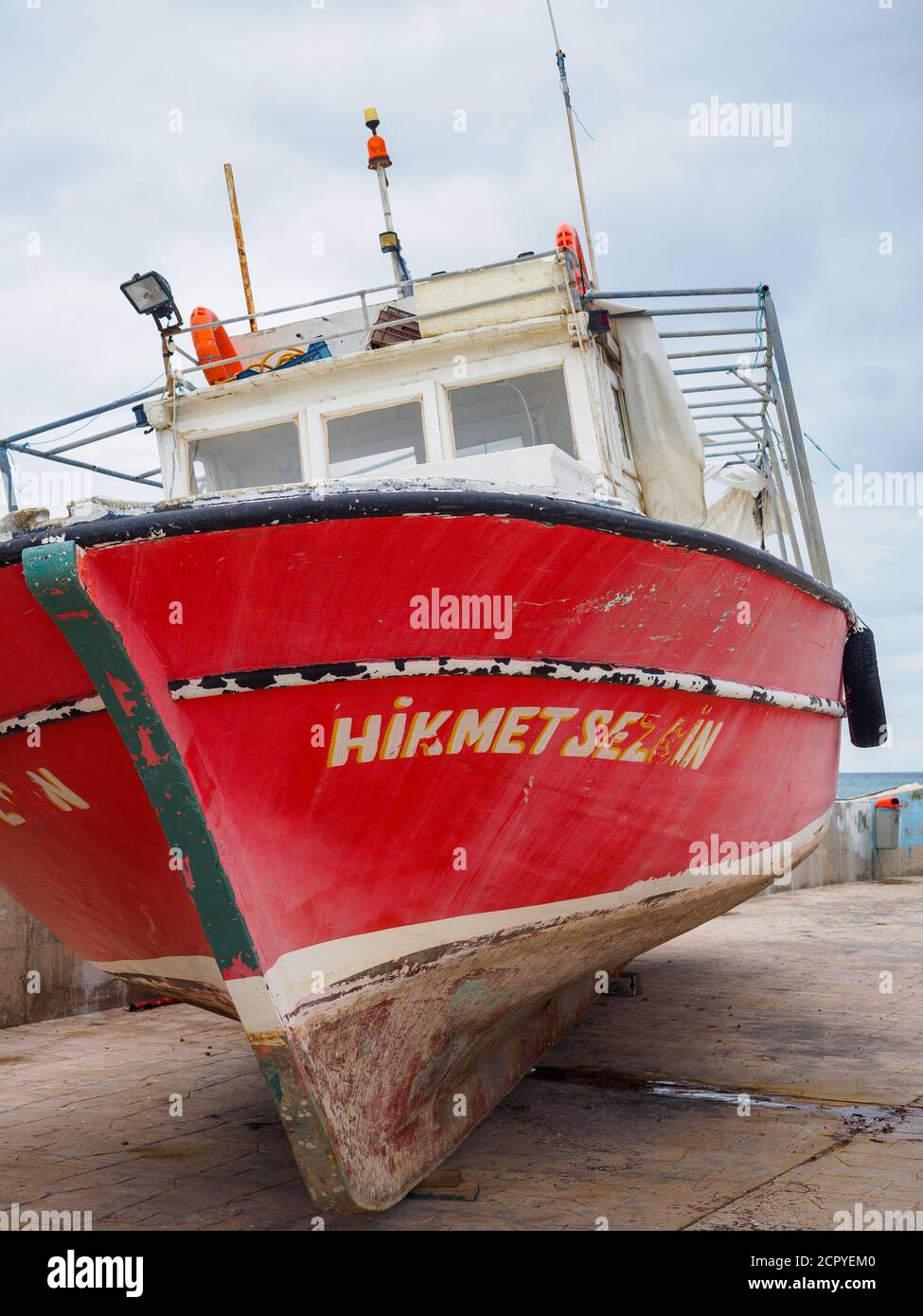 Barca da pesca rossa ormeggiata a secco sul porto, porto di Latchi, Cipro Foto Stock