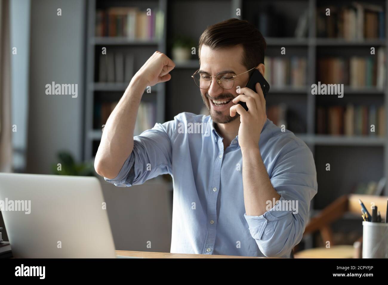 Il giovane trionfo eccitato riceve buone notizie online Foto Stock