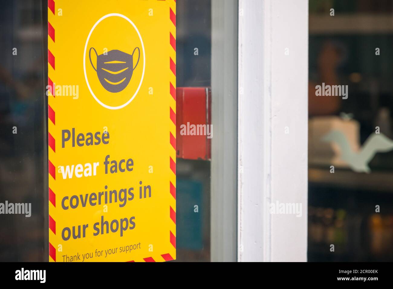 Suffolk, Regno Unito - 1 agosto, 2020 - cartello segnaletico per rivestimenti di viso esposto all'esterno di un negozio nella città di Southwold Foto Stock