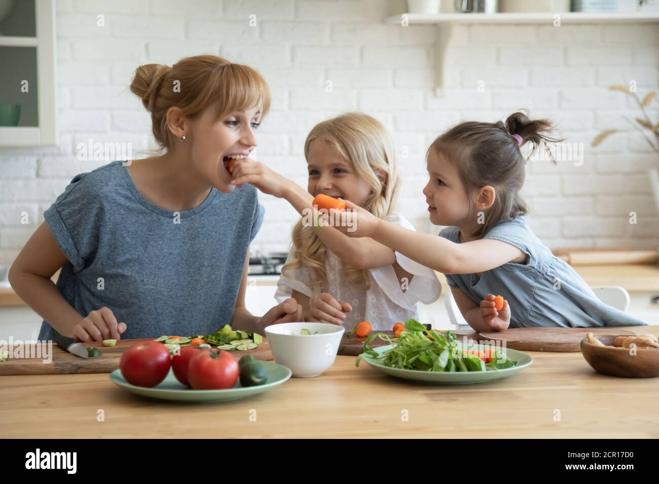 Le figlie premurose stanno alimentando la mummia con le verdure Foto Stock