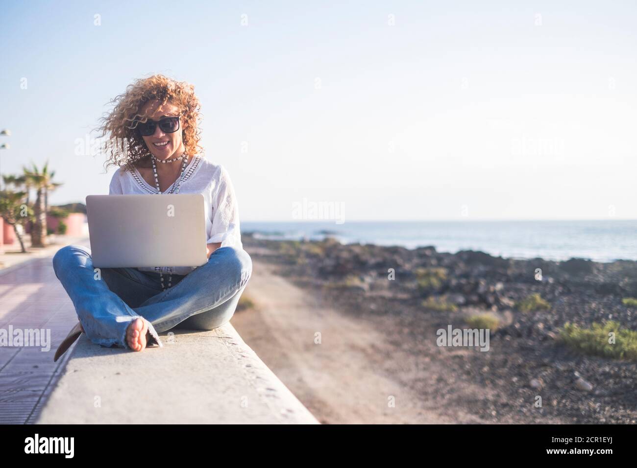 Felice stile di vita nomade digitale giovane donna allegra lavoro all'aperto con computer portatile - persone e tecnologia moderna lavoro e comunicazione correlati - al Foto Stock