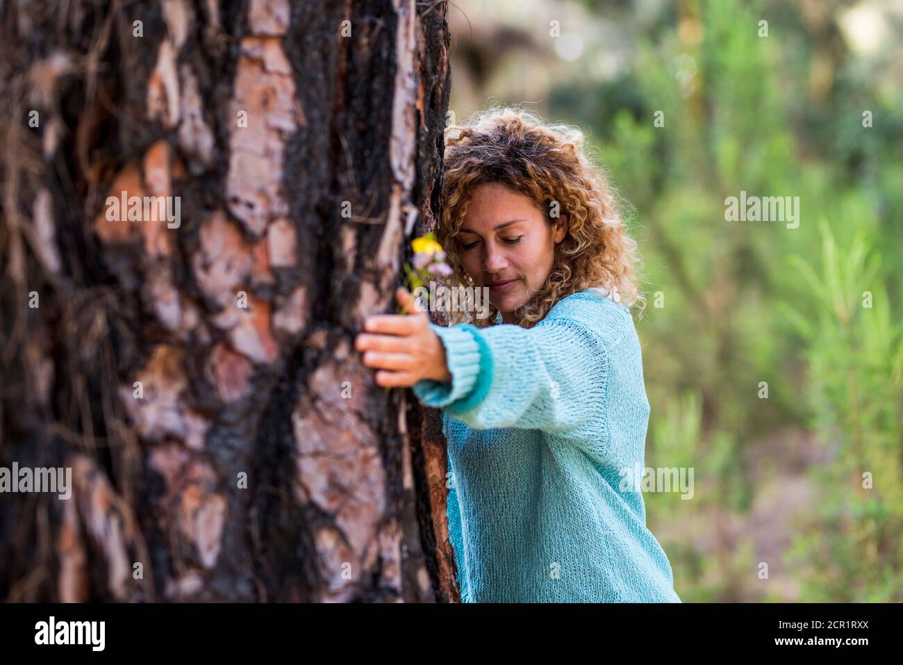 Persone e salvare il concetto di natura con la donna abbracciando un albero con amore e cura - salvare il pianeta e il clima cambiare problema globale di warmin preoccupato - Foto Stock