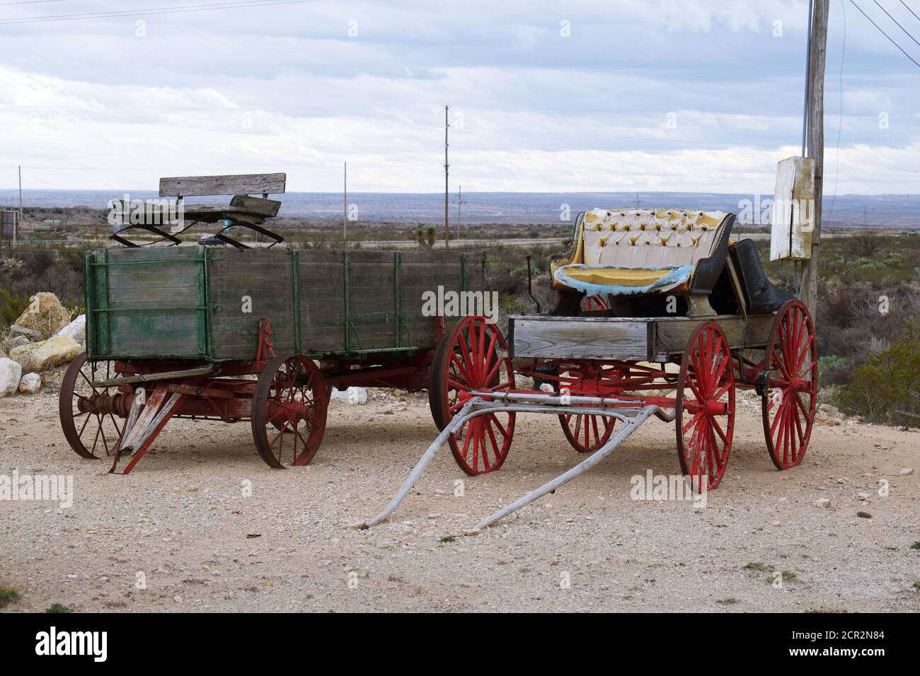 Old moda cavallo-trainato legno Stage Coach o vagone coperto nel deserto lotto in mostra. i Foto Stock