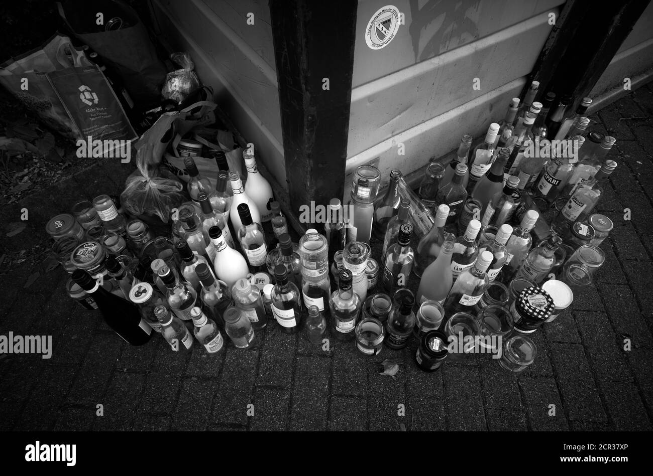 Bottiglie vuote di fronte ai contenitori di rifiuti in eccesso, Stoccarda, Baden-Württemberg, Germania Foto Stock