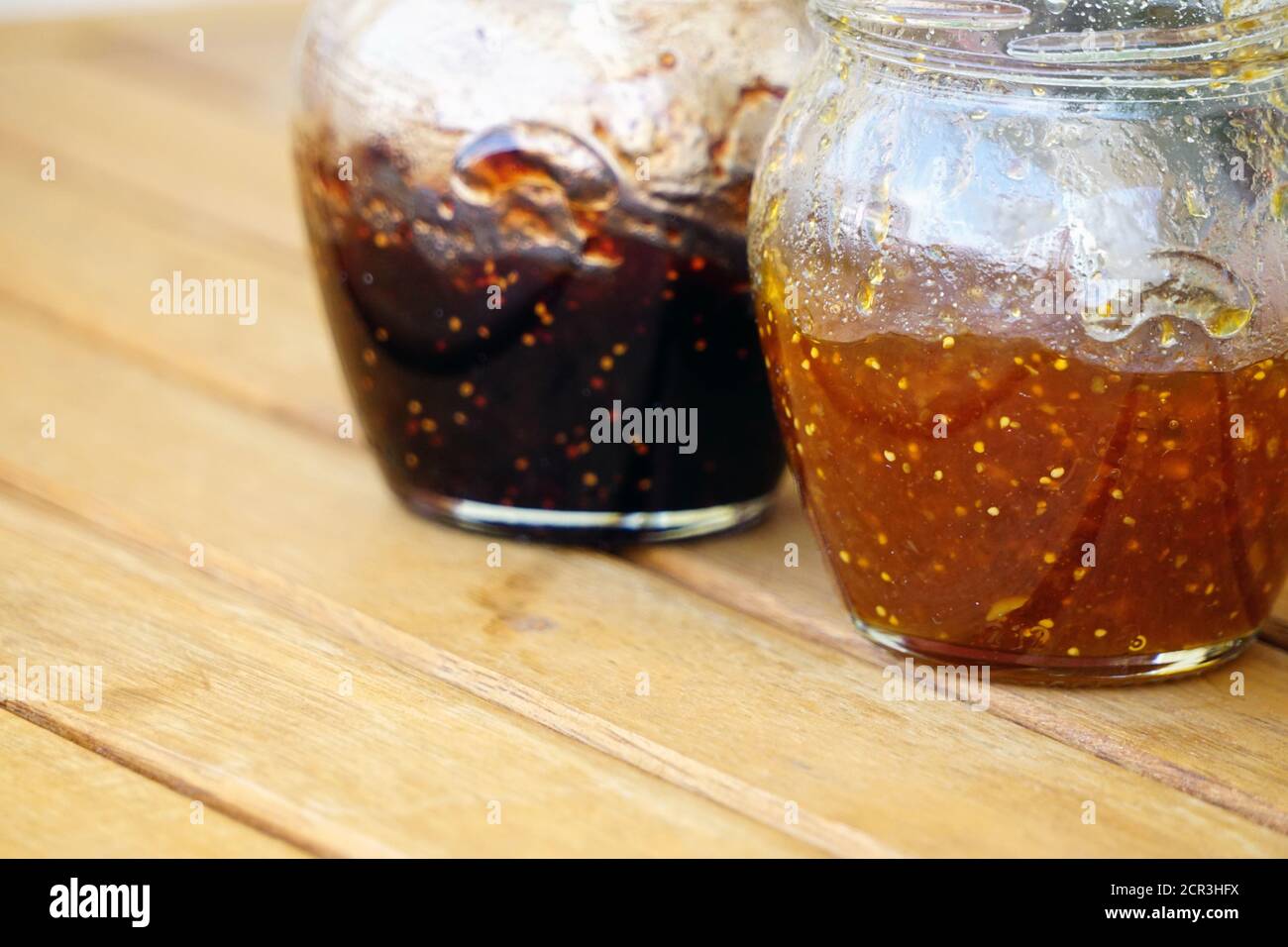 Vaso marmellata di fichi e arancio su sfondo di legno Foto Stock
