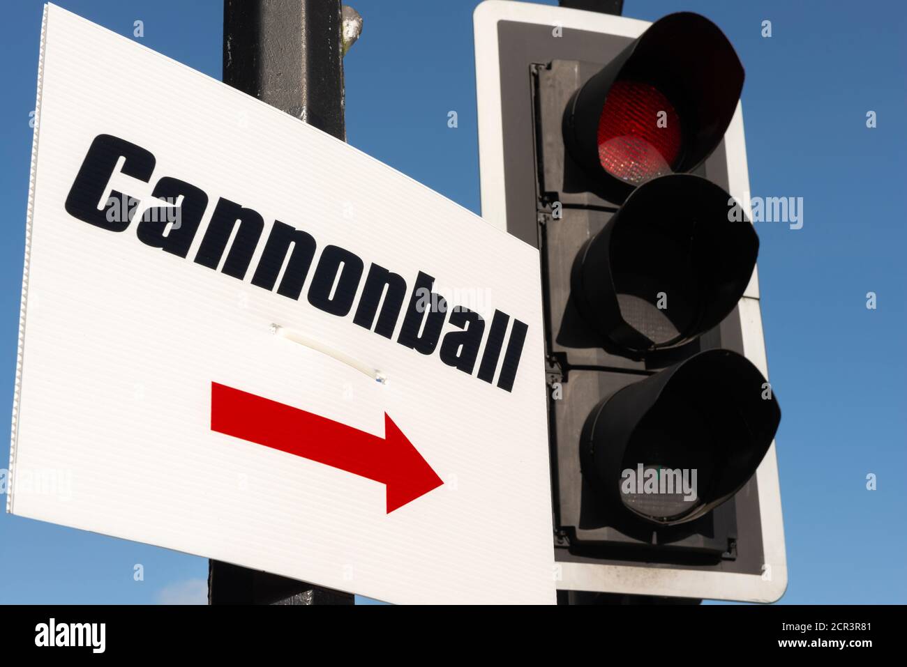 Cannonball Run semplice segnale di direzione fai da te in plastica corrugata e semafori contro il cielo blu Foto Stock