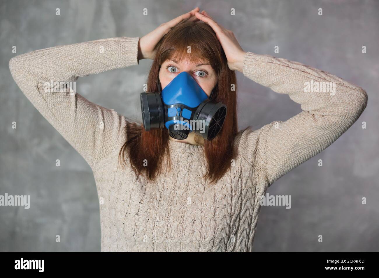 Ragazza spaventata dalle notizie di diffusione del virus. Donna in respiratore su sfondo scuro. Sanità, panico e concetto di paura. Foto Stock