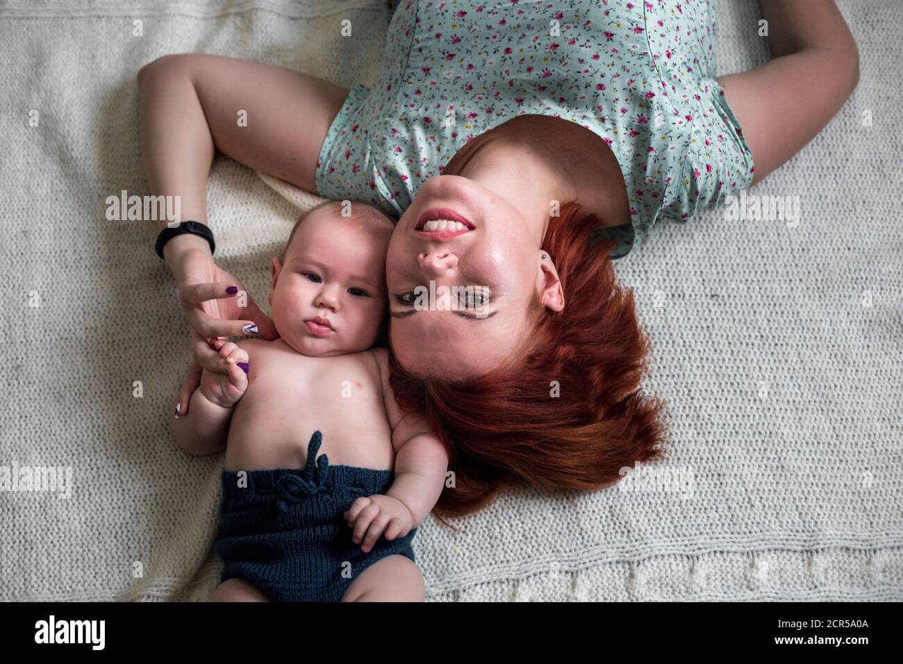 primo piano ritratto di mamma e bambino che giace sul pavimento Foto Stock