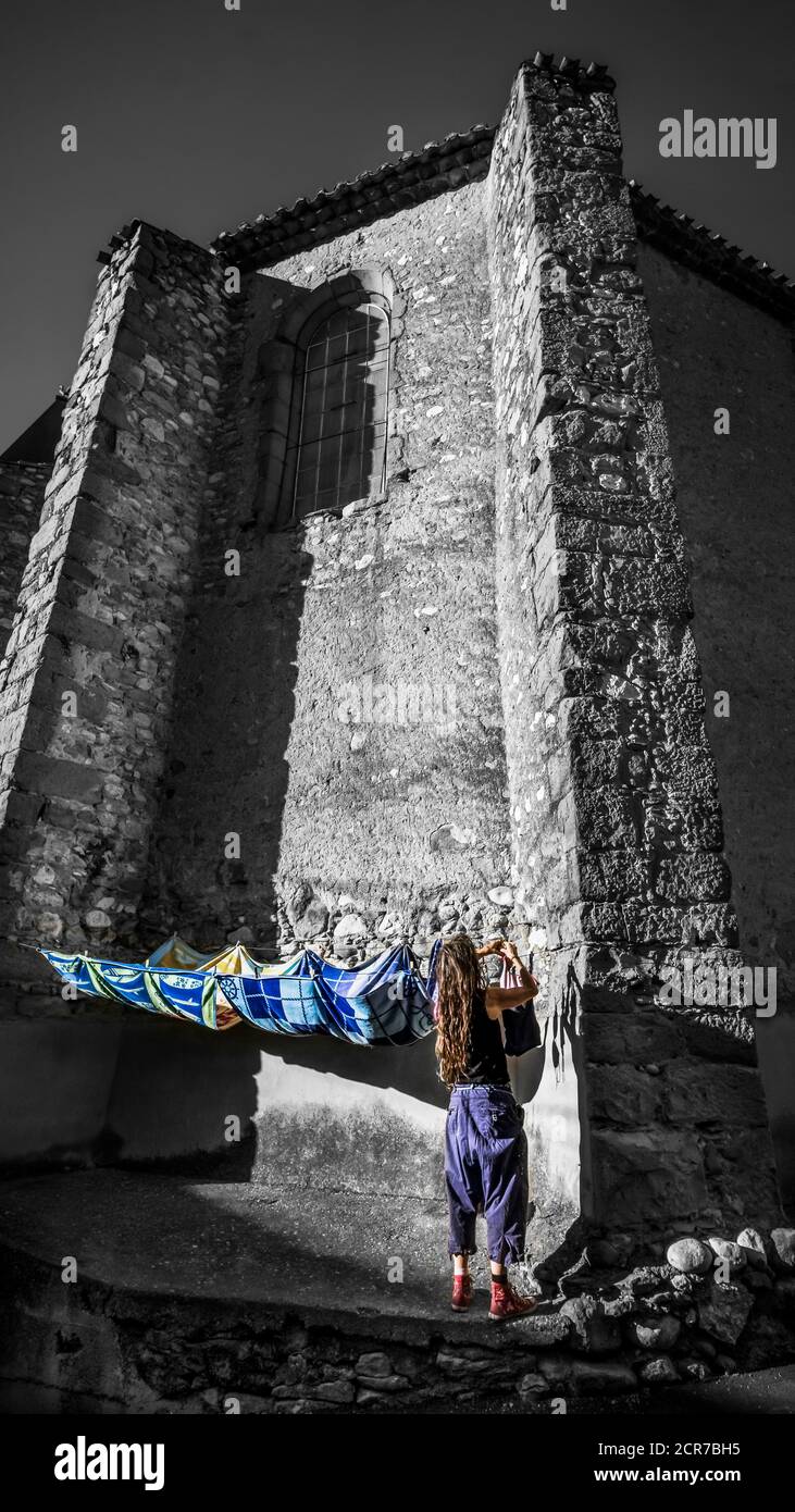Donna appesa lavanderia sulla parete posteriore della chiesa di Saint Laurent. Monumento historique. Foto Stock
