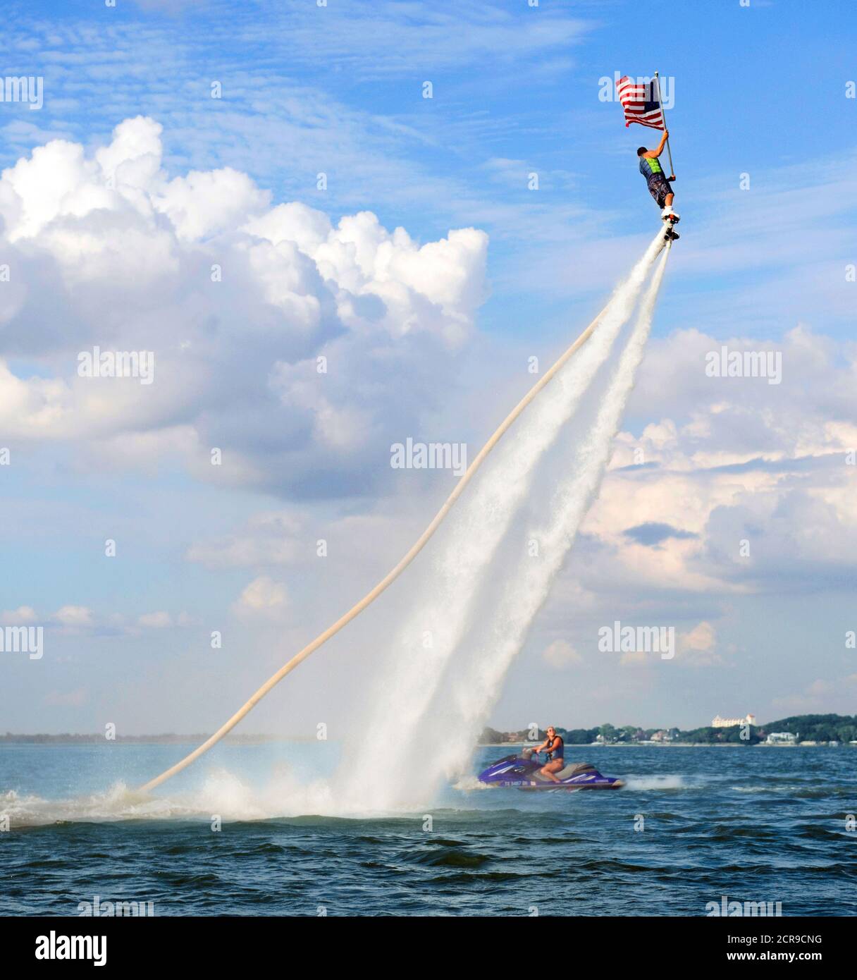 Rocket Man volare su una Jet Fly Board al lago Arlington, Texas e tenendo una bandiera americana. Foto Stock