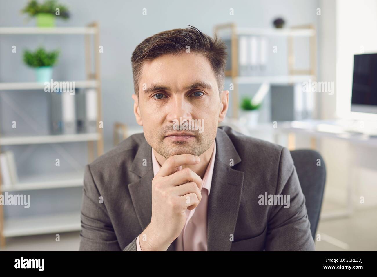 Uomo d'affari che guarda la telecamera durante la videocamera in ufficio Foto Stock