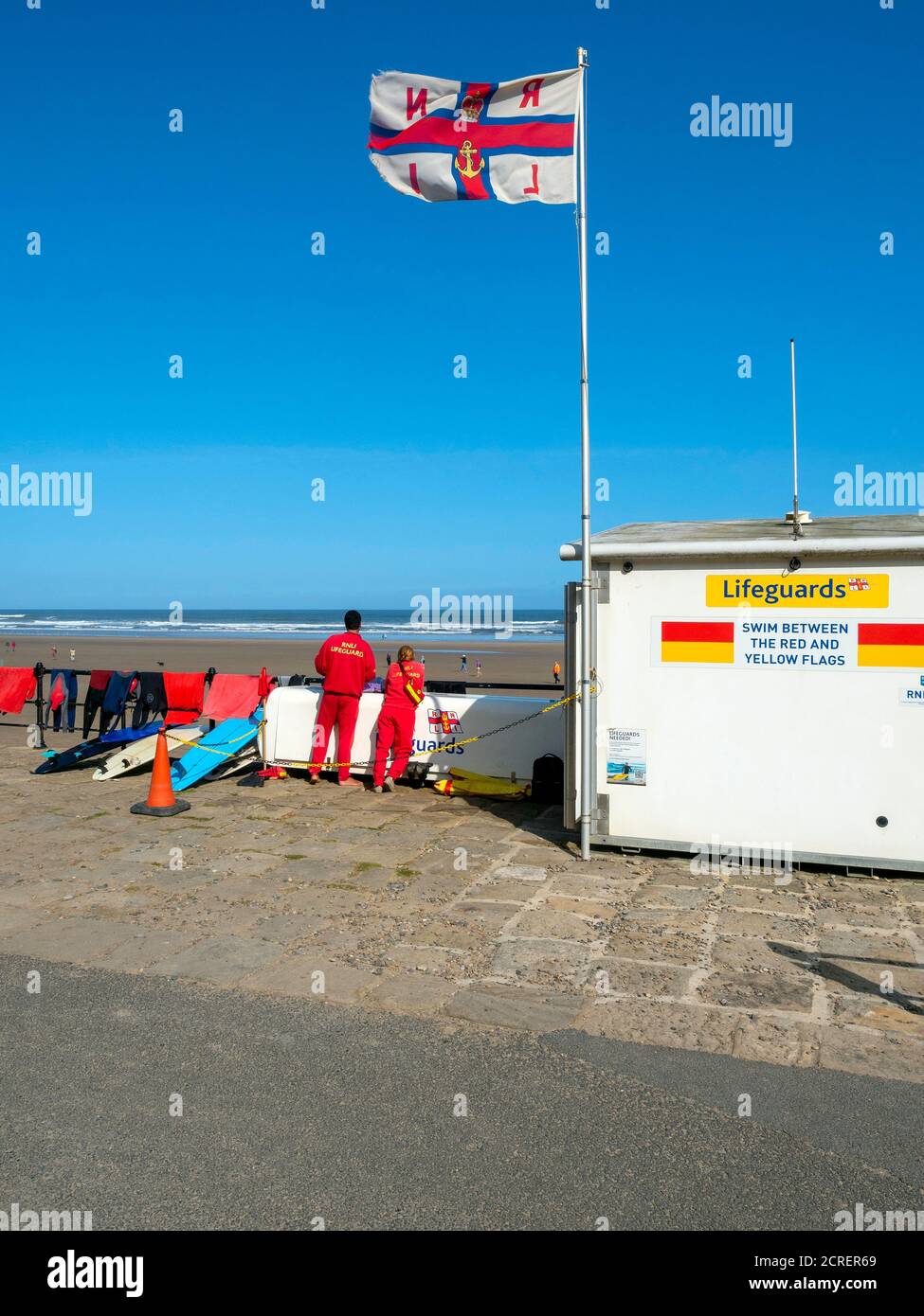 Due bagnini presso un posto di guardia di vita sulla spiaggia RNLI La scuola di surf spiaggia di formazione Saltburn North Yorkshire Inghilterra Foto Stock