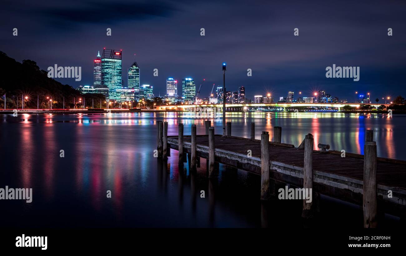 Un'immagine notturna cupa della città di Perth dall'interno dell'Old Swan Brewery. Il molo punta verso il ponte Narrows e lo skyline della città. Foto Stock