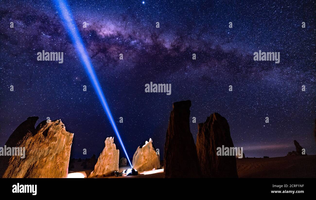 Uomo che si posa nei pinnacoli Australia occidentale con torcia da testa Guardare la Via Lattea Foto Stock