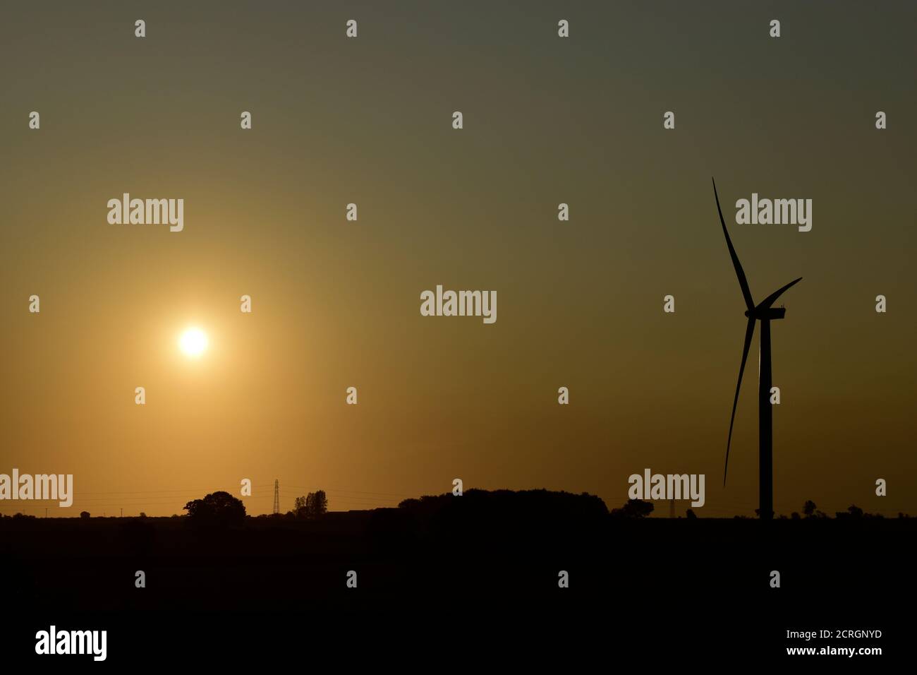 La silhouette della turbina eolica nella fattoria eolica di Burton Wold all'alba. Fornitore sostenibile di energia elettrica a zero emissioni di carbonio tramite generatore di energia eolica, energia verde. Foto Stock