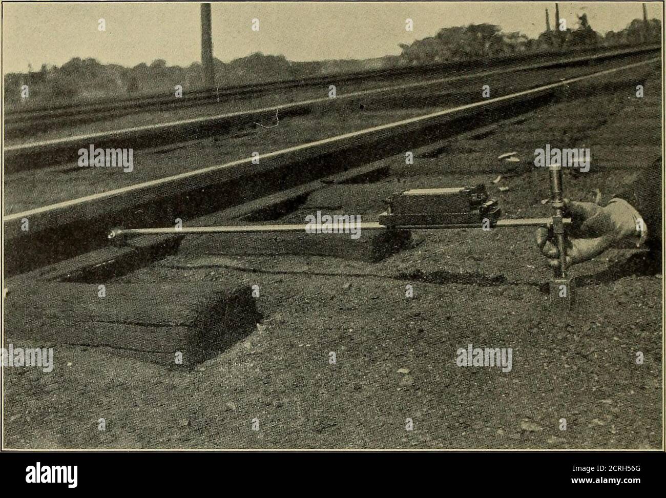 . I binari in acciaio; la loro storia, le loro proprietà, la loro resistenza e la loro produzione, con note sui principi del materiale rotabile e della progettazione dei cingoli . TENSIONE DI COMPRESSIONE Fig. 159. - Railroad Track Experiments, Boston e Albany R. IT. Un fascio che porta un micrometro e una bolla astronomica di livello sono stati usedin osservando la depressione della rotaia (vedere Fig. 160), misurando dapprima l'altezza,utilizzando punti sulla flangia esterna, quando la rotaia è stata scaricata, e ripetendo leosservazioni quando il motore era in piedi sulla pista. È stato trovato che il letto stradale in prossimità dei locomotori era sensibile e depresso Foto Stock