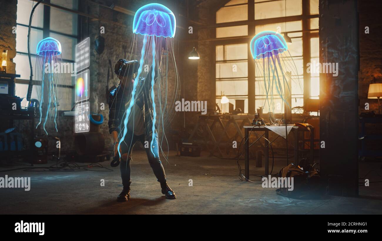 Donna artista indossando Augmented Reality Headset lavorare su Abstract 3D Jellyfish scultura con joystick, utilizza i gesti per creare Internet High-Tech Foto Stock