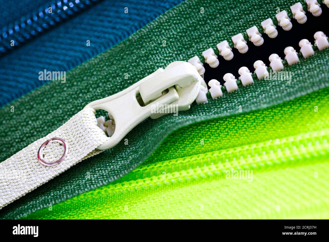 Zip fondo texture di zipper slider. Un sacco di zip in diversi colori. Abiti da cucire, atelier, tessuto e negozio di accessori. Hobby fai da te conce Foto Stock