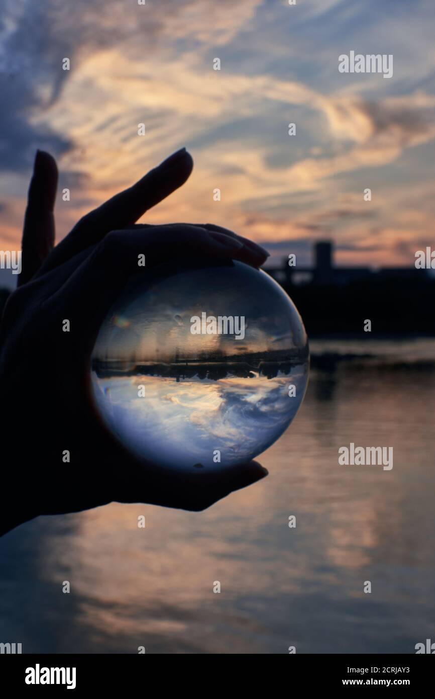 Guardando attraverso un lensball di fronte al bellissimo tramonto sopra l'acqua Foto Stock