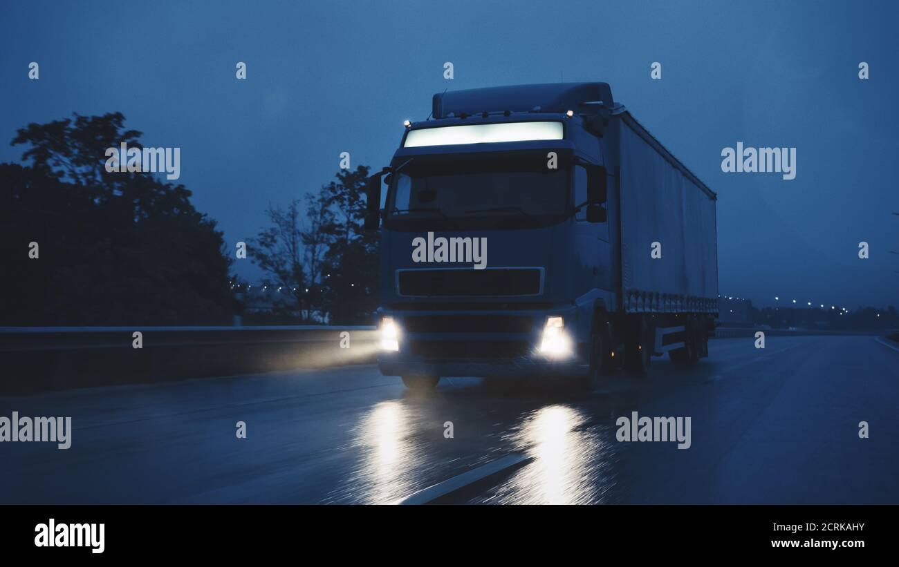 Long Haul semi-Truck con Cargo Trailer Full of Goods viaggia di notte sulla Freeway Road, guidando attraverso il Continente attraverso pioggia, nebbia, neve Foto Stock