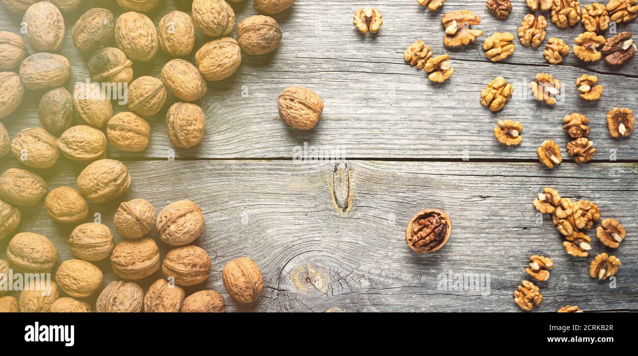 Cumulo di nocciole fresche e noci intere su tavola di legno - naturale motivo di fondo dettaglio. Primo piano della superficie marrone. Sano organico Foto Stock