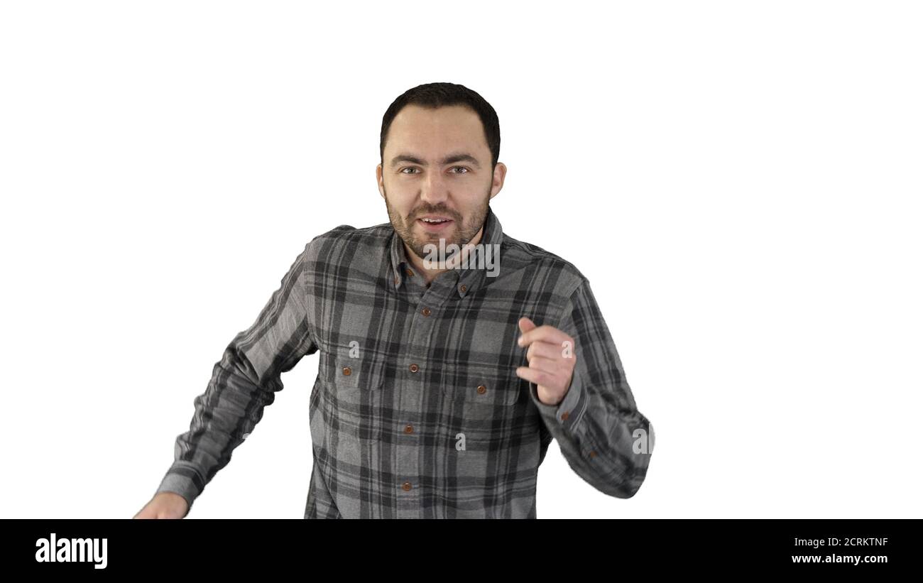 Bell'uomo che cammina, canta e balla alla musica su bianco Foto Stock