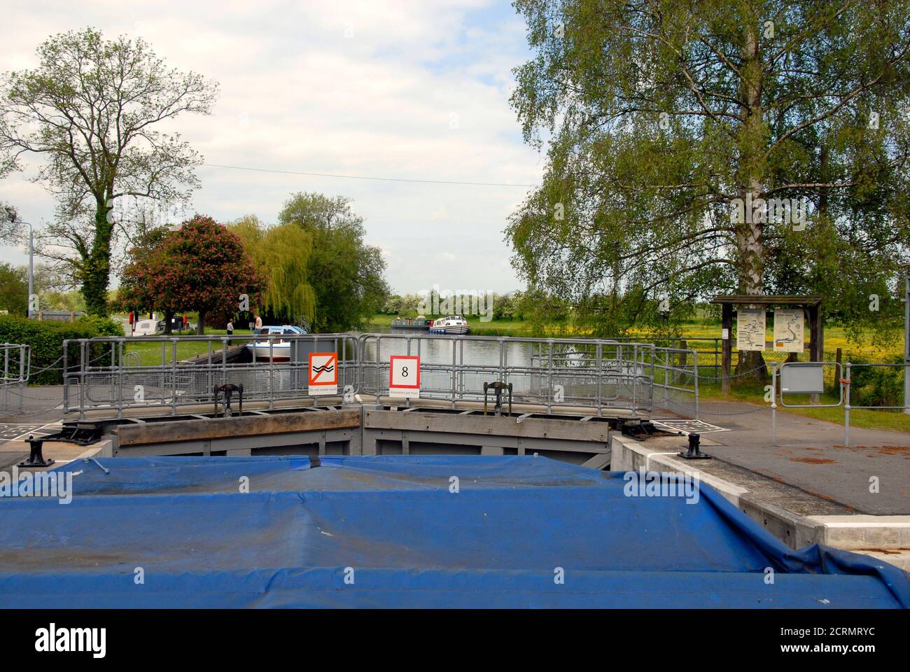Barca in blocco sul fiume Tamigi, Oxfordshire, Inghilterra con cancelli chiusi e mostrando segnali di avvertimento circa la mancata creazione di lavaggio e un limite di velocità di 8 km/h. Foto Stock