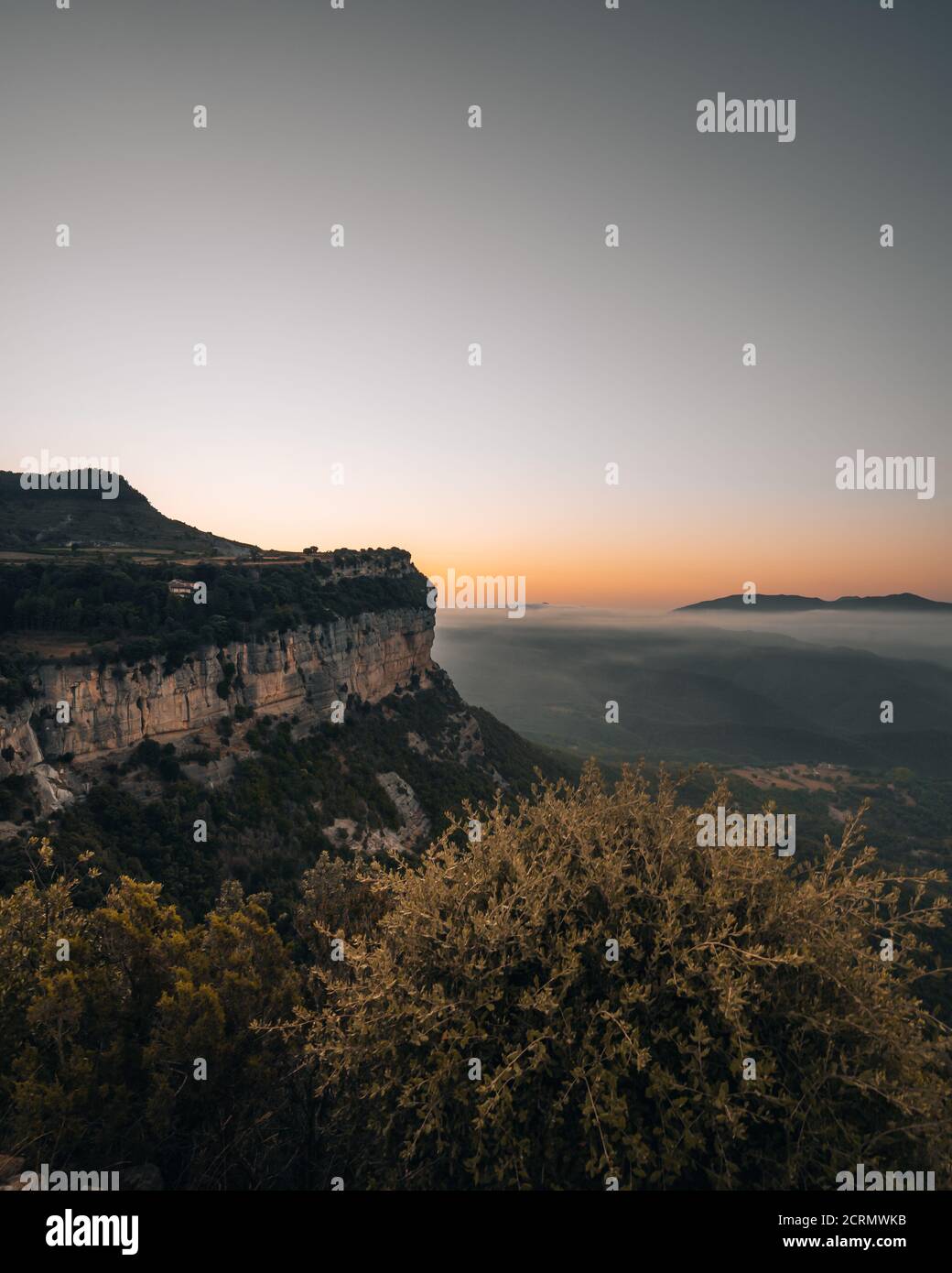 Immagine verticale di un bellissimo paesaggio di scogliere boschive e. montagne misty Foto Stock