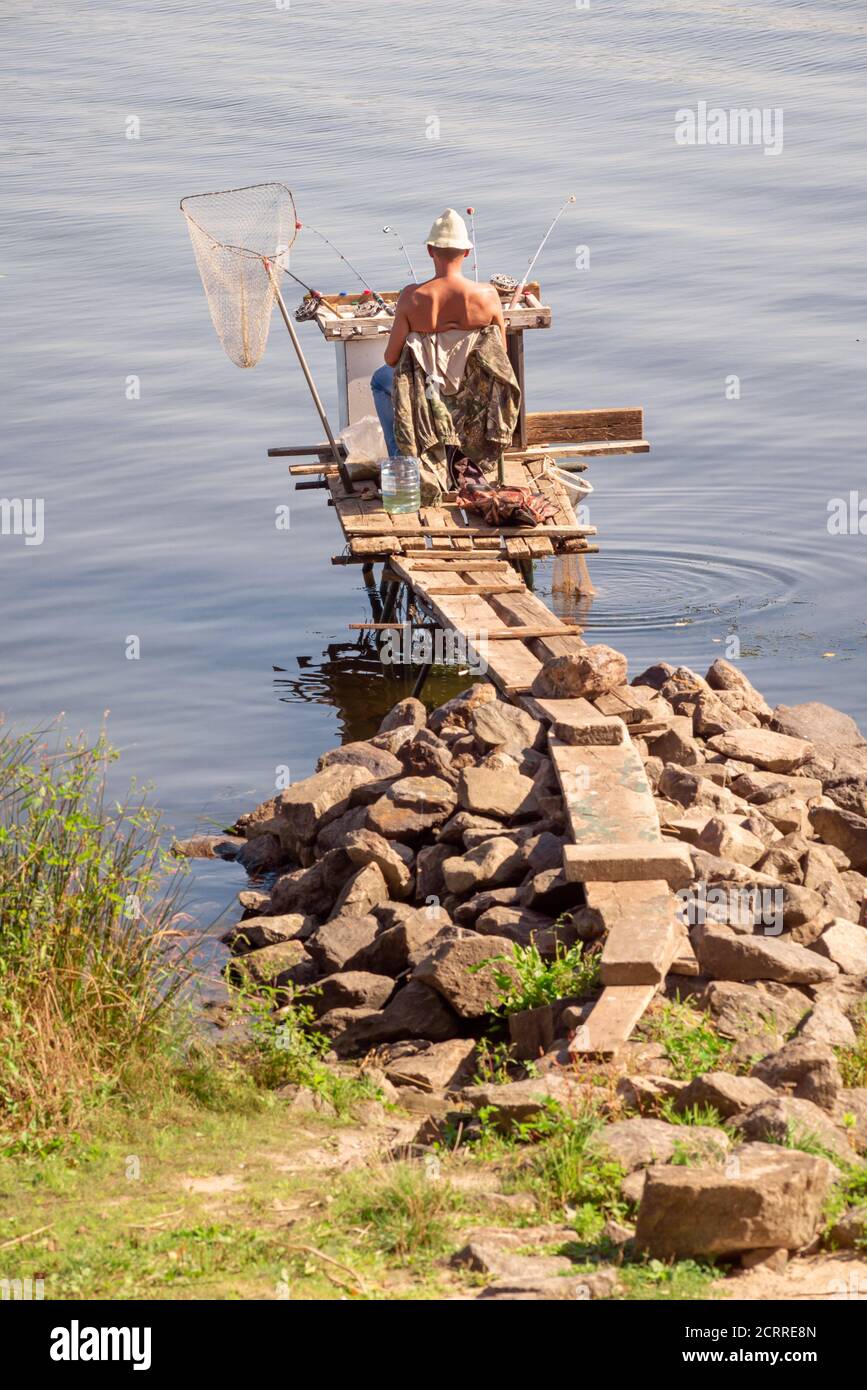 Kiev / Ucraina - 10 settembre 2020 - Pescatore sul fiume Dnieper a Kiev, Ucraina durante un bel pomeriggio di sole d'estate Foto Stock