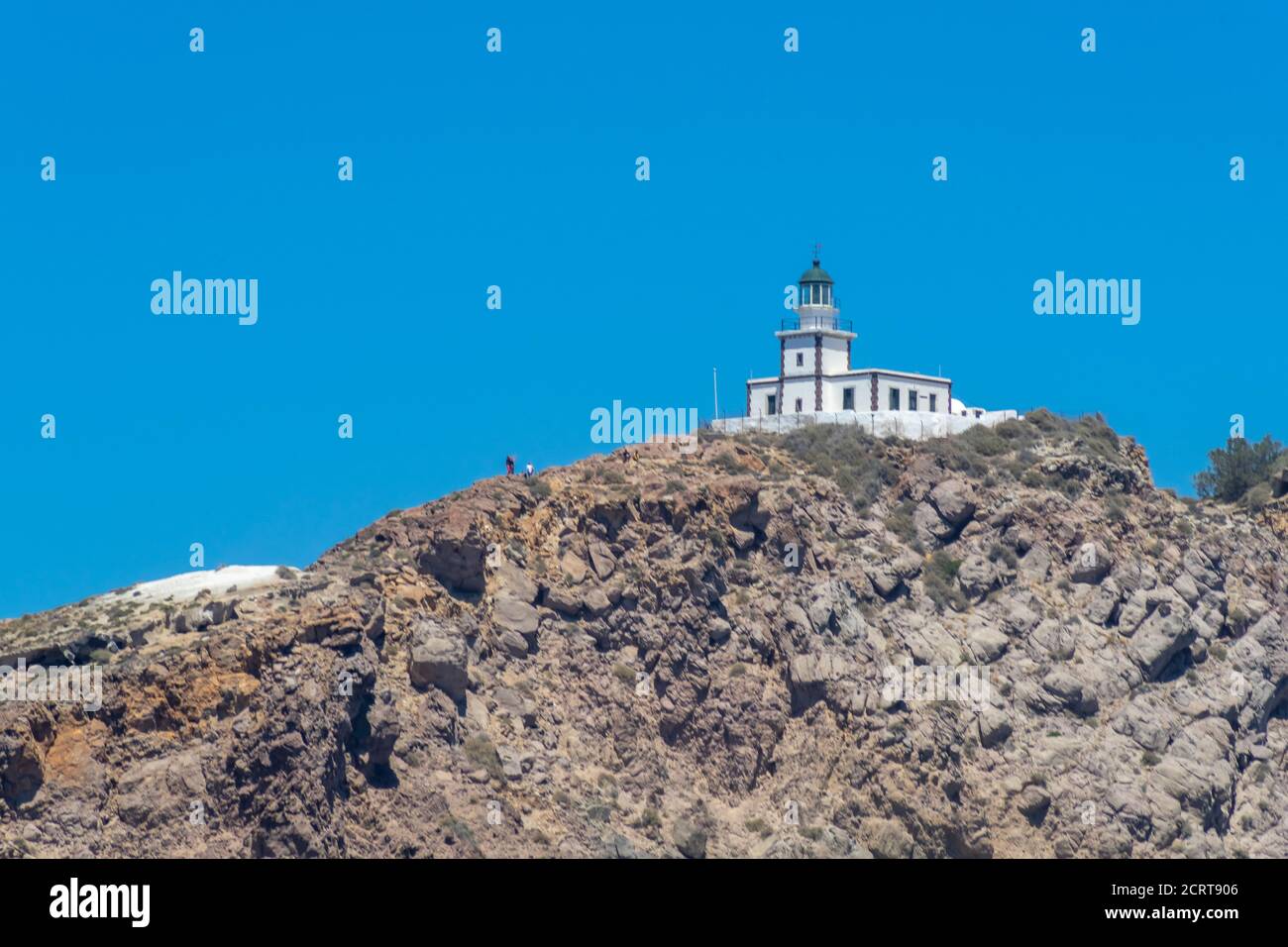 Scogliera e faro a sud dell'isola di Thira, nelle isole greche, in una giornata limpida e soleggiata con cielo blu e luminoso. Akrotiri, Santorini, Grecia. Akroti Foto Stock