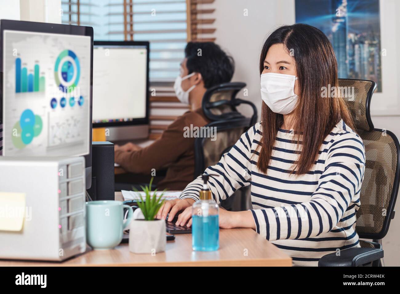 Coppia di colleghi asiatici che indossano la maschera chirurgica e che lavorano con il computer in ufficio domestico quando Covid-19 pandemia, focolaio di Coronavirus, istruzione A. Foto Stock Coppia di colleghi asiatici che indossano la maschera chirurgica e che lavorano con il computer in ufficio domestico quando Covid-19 pandemia, focolaio di Coronavirus, istruzione A. Foto Stock