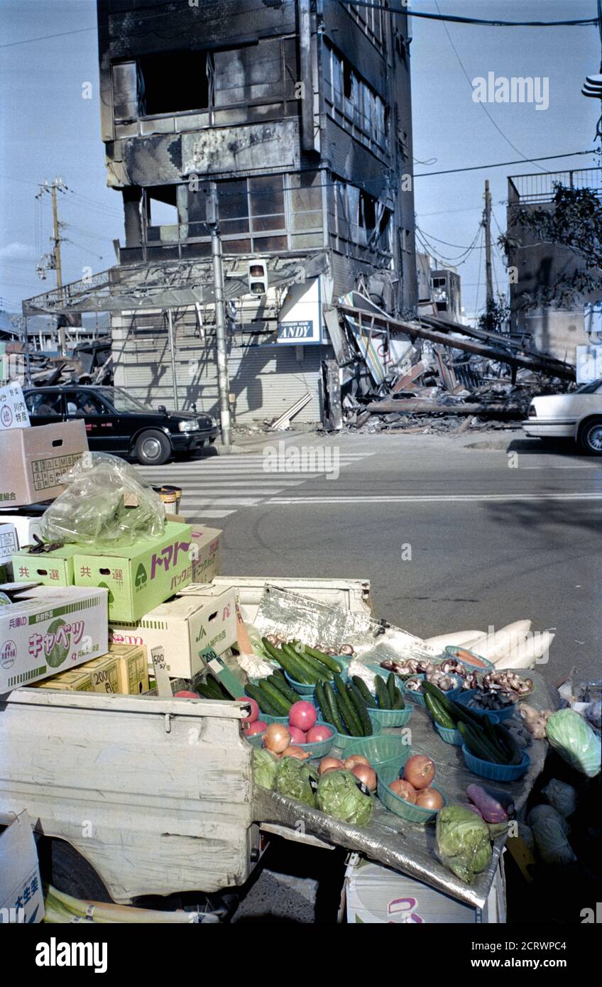 Le verdure che vengono vendute dal retro di un camion di fronte alle rovine bruciate che mostrano le conseguenze del Grande terremoto di Hanshin del 1995 a Kobe, Giappone Foto Stock