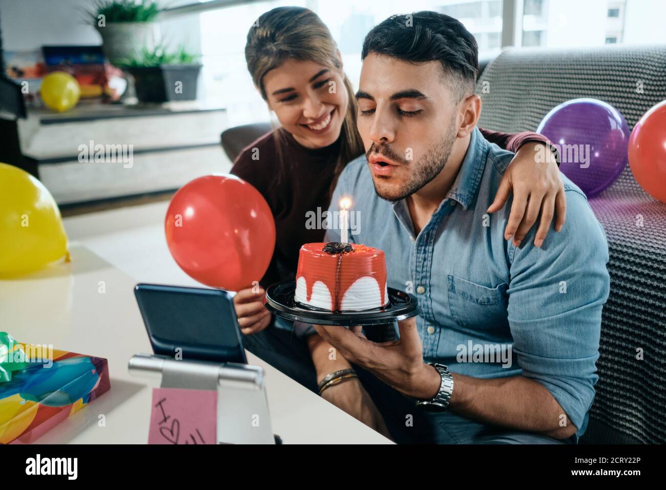 Felice gente che celebra la festa di compleanno via Zoom su smartphone Foto Stock