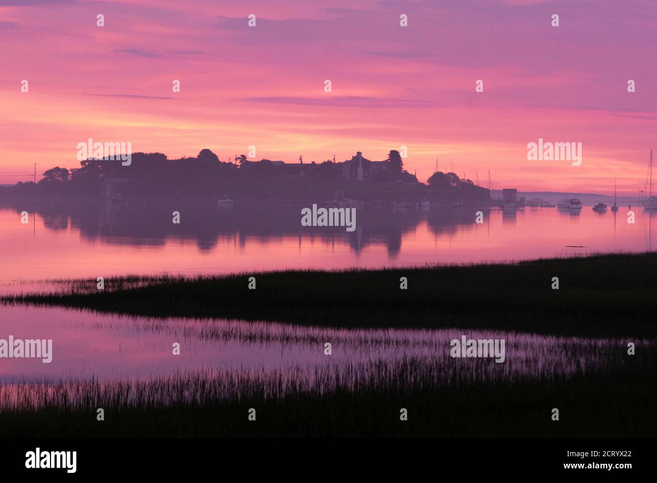 La luce Dawn illumina un rosa vibrante sopra la piscina di Biddeford sulla costa del Maine. Foto Stock