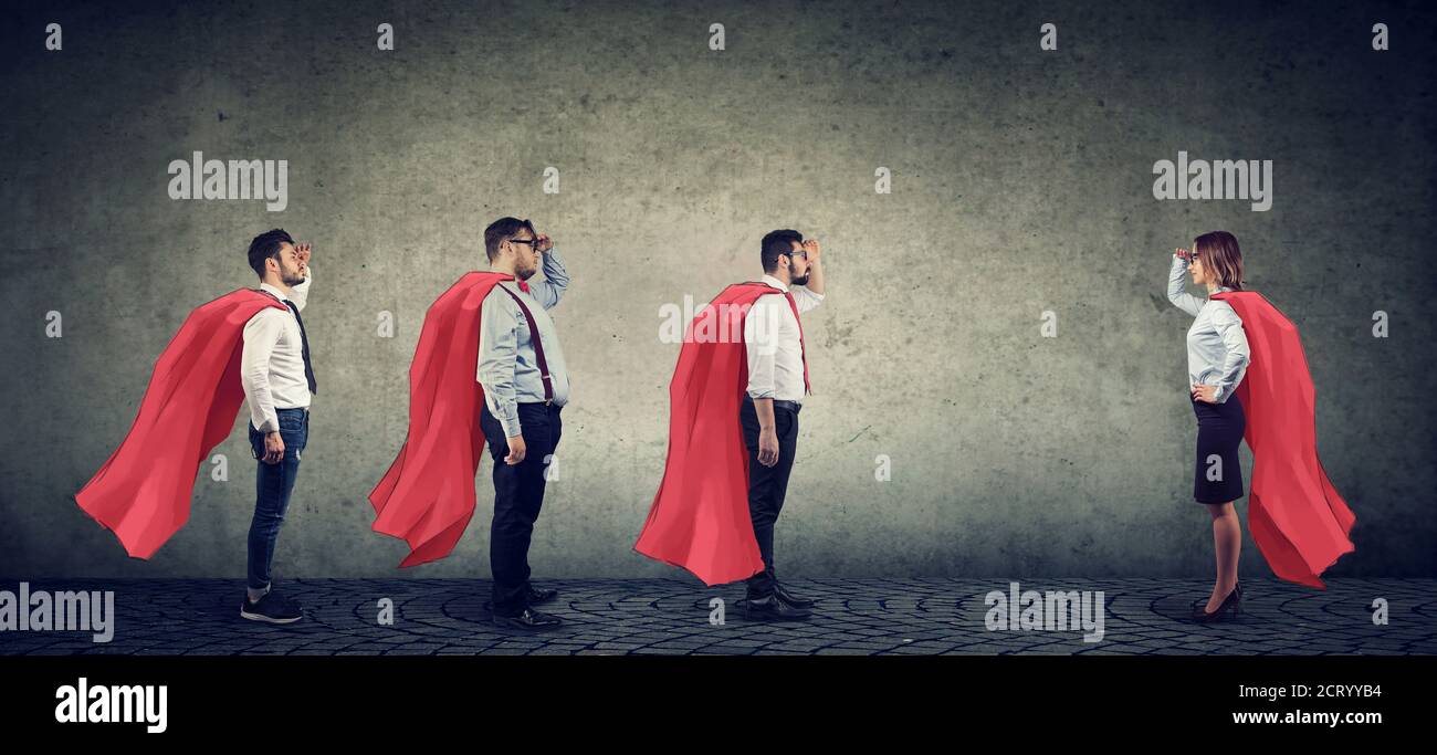 Gruppo di tre uomini e una donna che immagina di essere un super eroe che si è aspirato l'uno all'altro Foto Stock