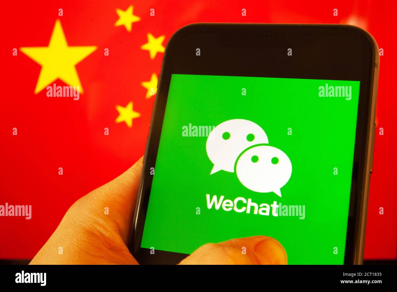 Cellulare con logo WeChat davanti alla bandiera della Cina. il presidente degli Stati Uniti Donald Trump vieta le applicazioni della Cina a causa della minaccia per la sicurezza nazionale. Foto Stock