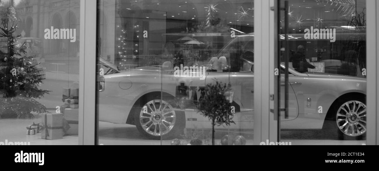 Vista attraverso una vetrina del Christmas Store su un'auto di lusso di marca. Bianco e nero. Immagine ad alta risoluzione Foto Stock