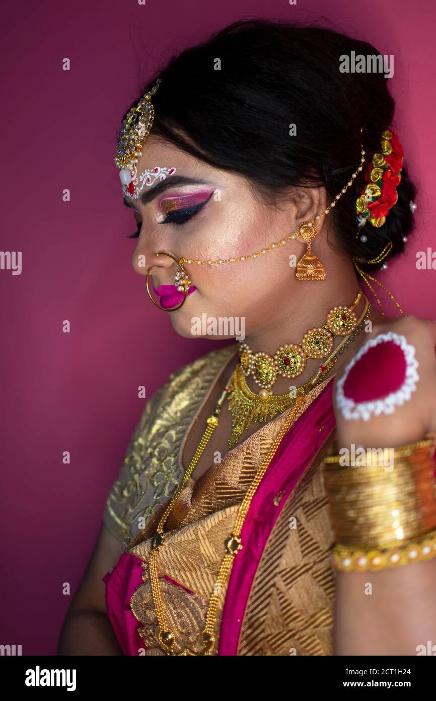 ritratto nuziale di signora indiana che indossa tradizionale saree e oro gioielli Foto Stock